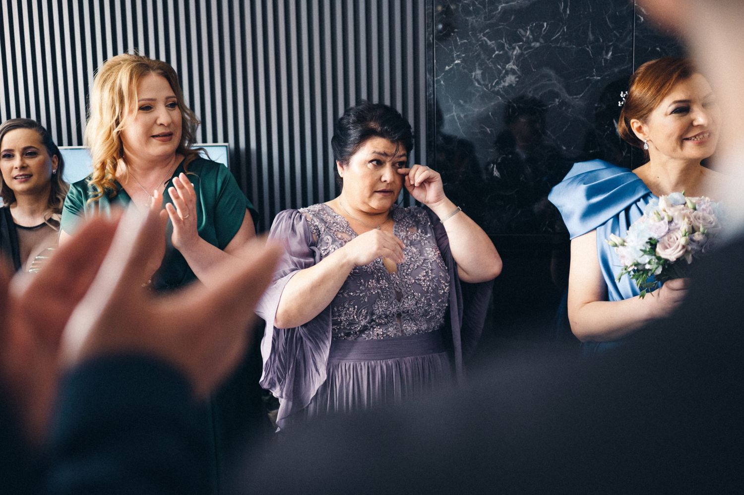 Wedding guests share an emotional moment during the celebration wearing formal attire.