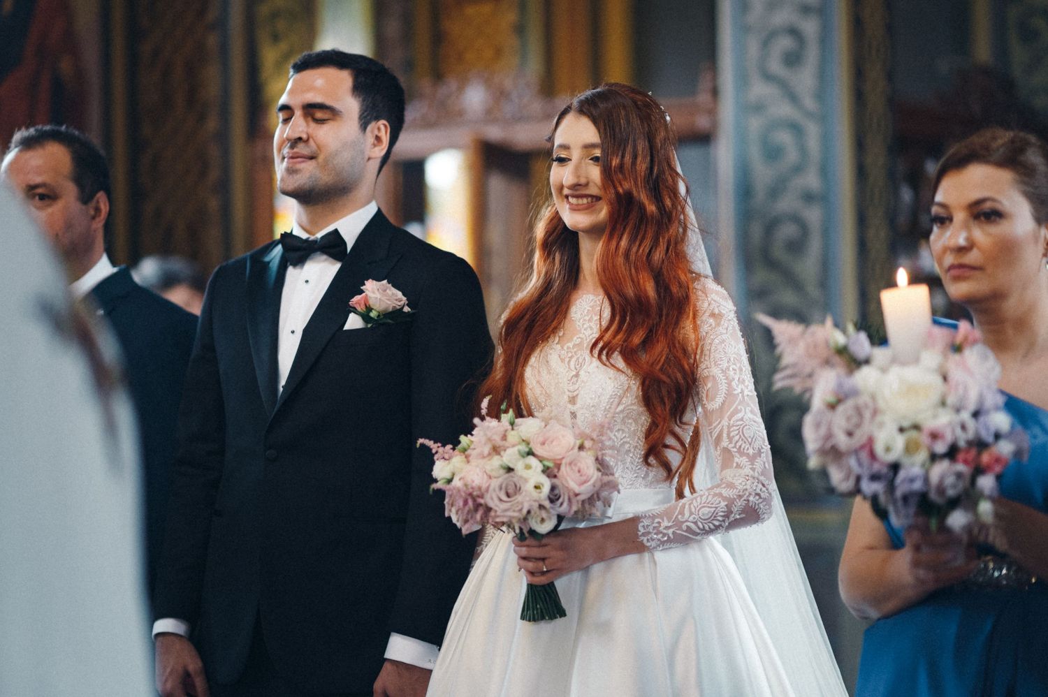 Couple during wedding ceremony in an ornate orthodox church with decorative interior.