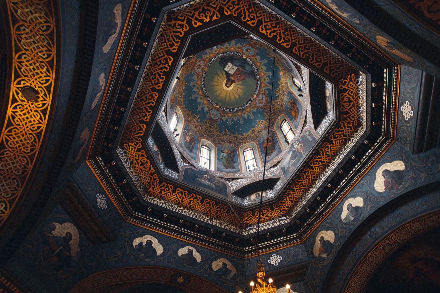Ornate octagonal church dome ceiling with golden decorative patterns and religious artwork in Orthodox style.