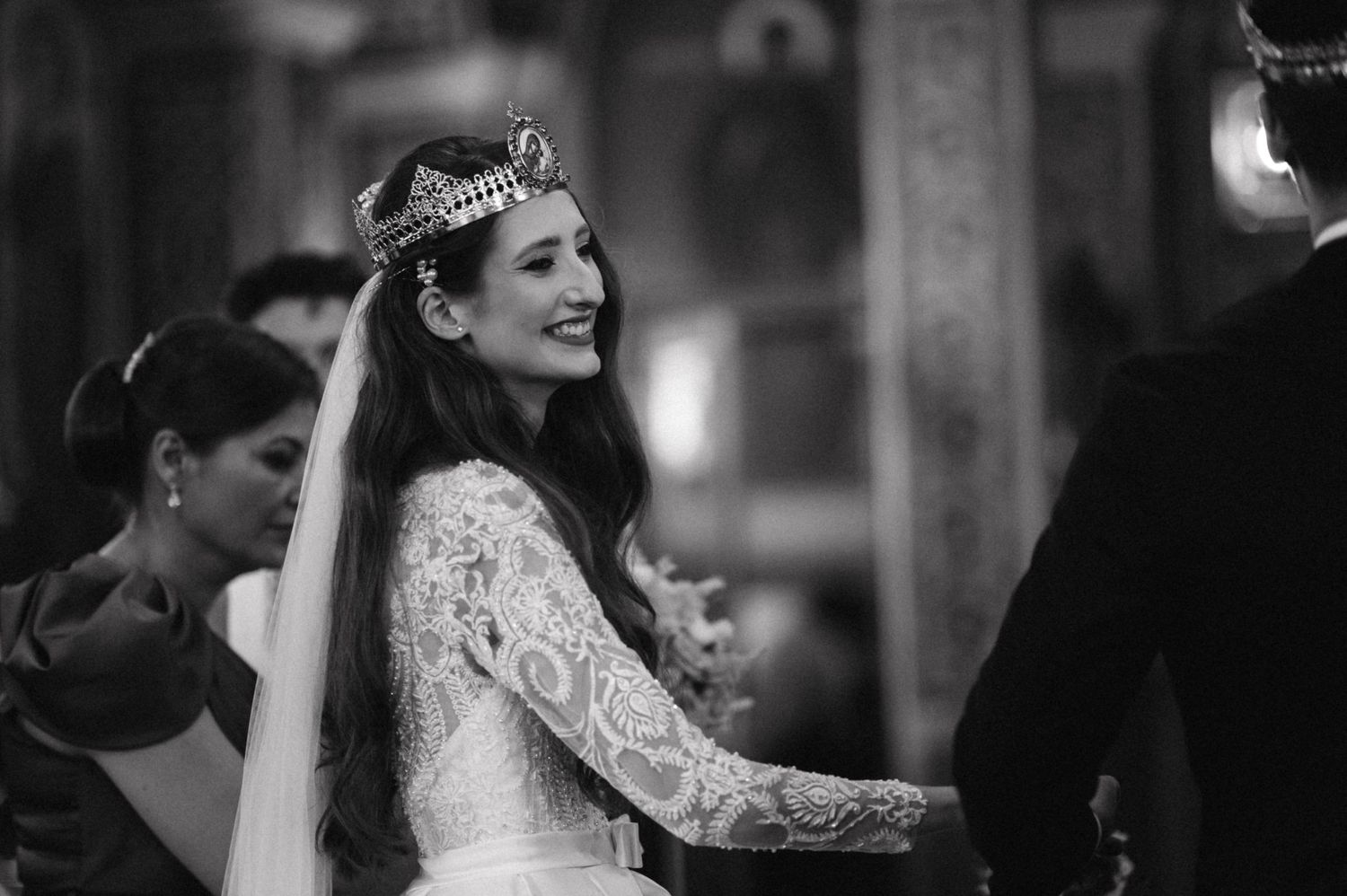 Black and white photo of Orthodox wedding ceremony with lace dress and ceremonial crown.