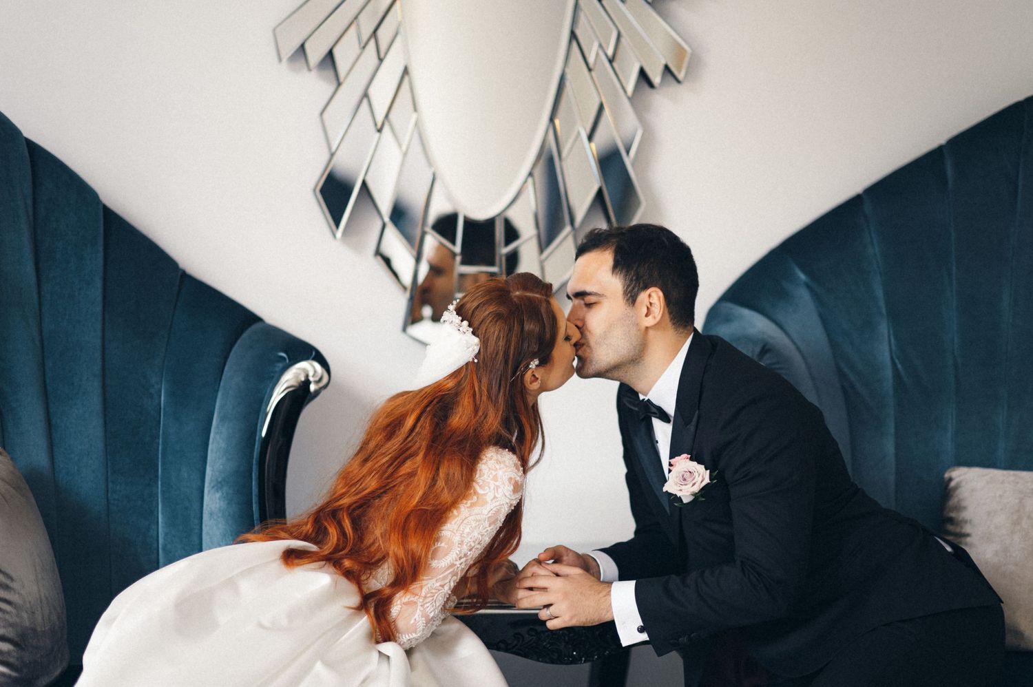 Romantic scene in blue velvet seating area with decorative mirror backdrop.