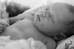 Peaceful sleeping newborn in black and white portrait.
