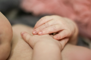 Macro shot of baby's tiny hand grasping with natural lighting.