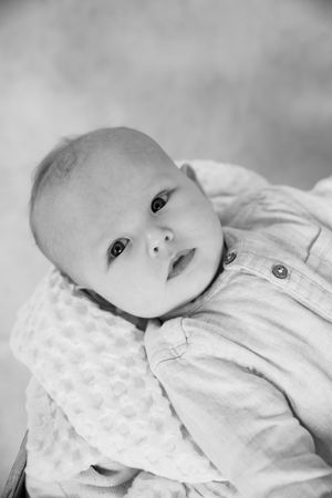 Black and white portrait of an infant wearing a light colored button-up outfit.