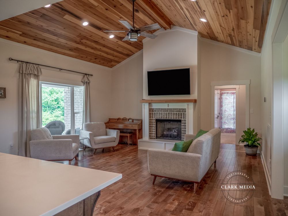 Contemporary living space with vaulted wooden ceiling, fireplace, and comfortable seating area.