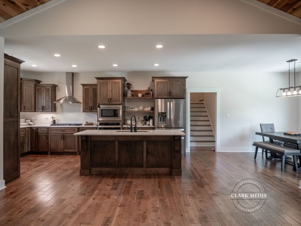 Open concept kitchen and dining area with hardwood floors and dark wood cabinets.