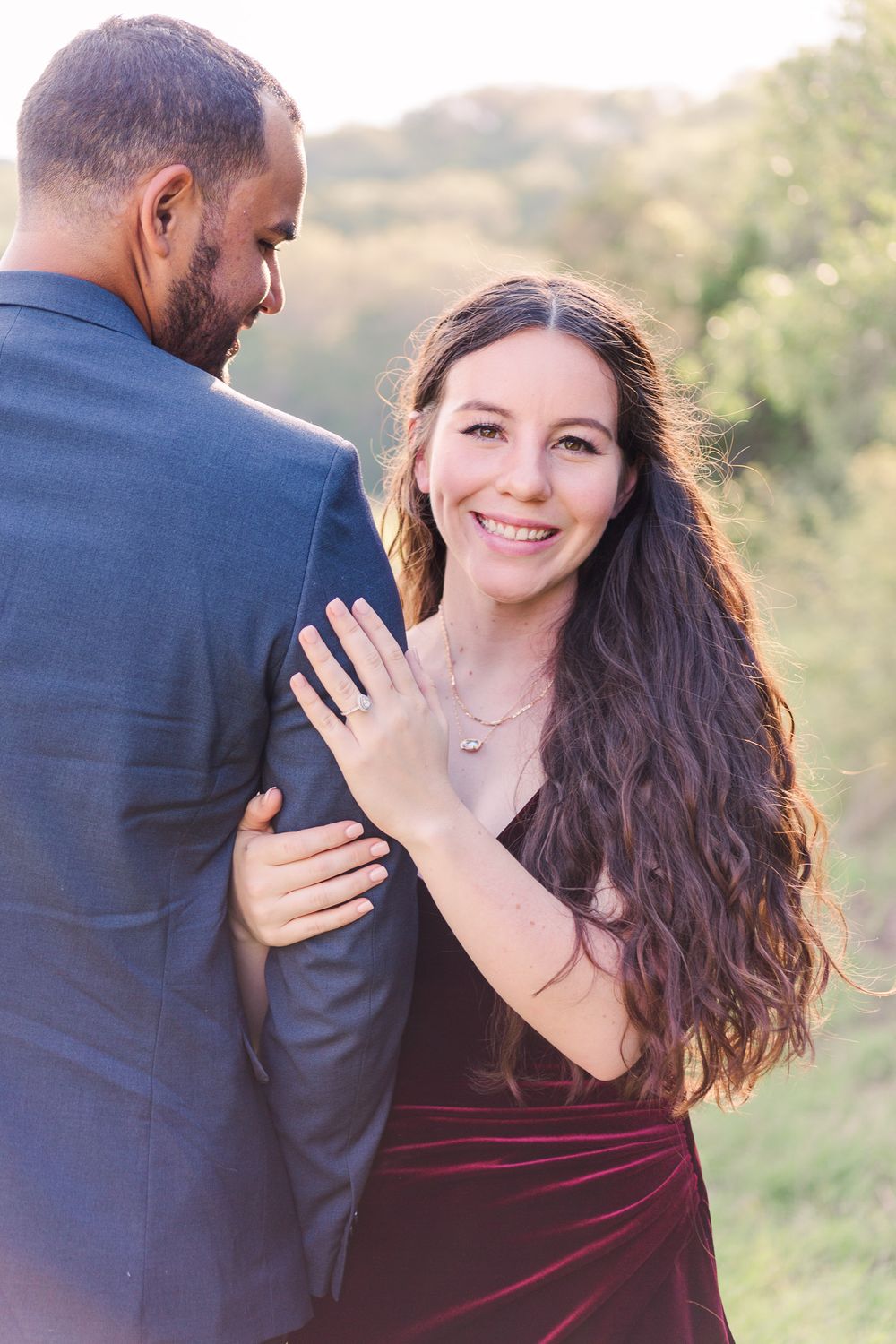 Happy couple embracing during outdoor engagement photoshoot.