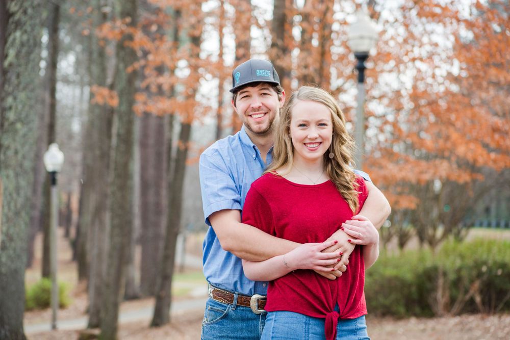 Happy couple laughing together on autumn pathway.
