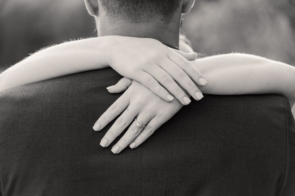 Close up of hands crossed in embrace during romantic photoshoot.