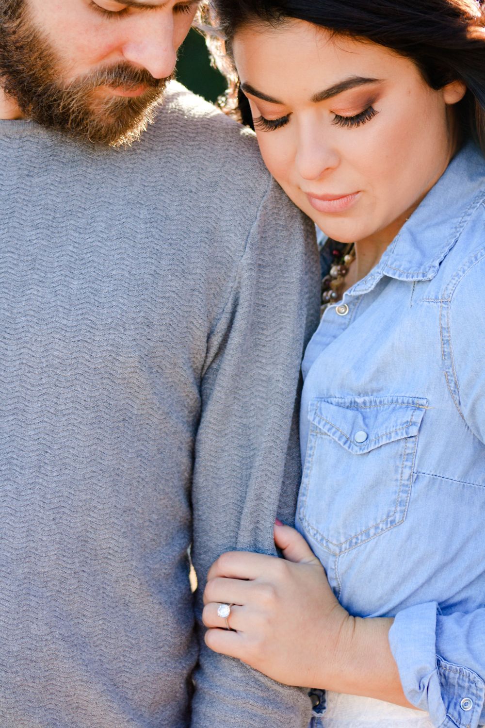 A tender close-up moment between a couple wearing casual denim and grey clothing.
