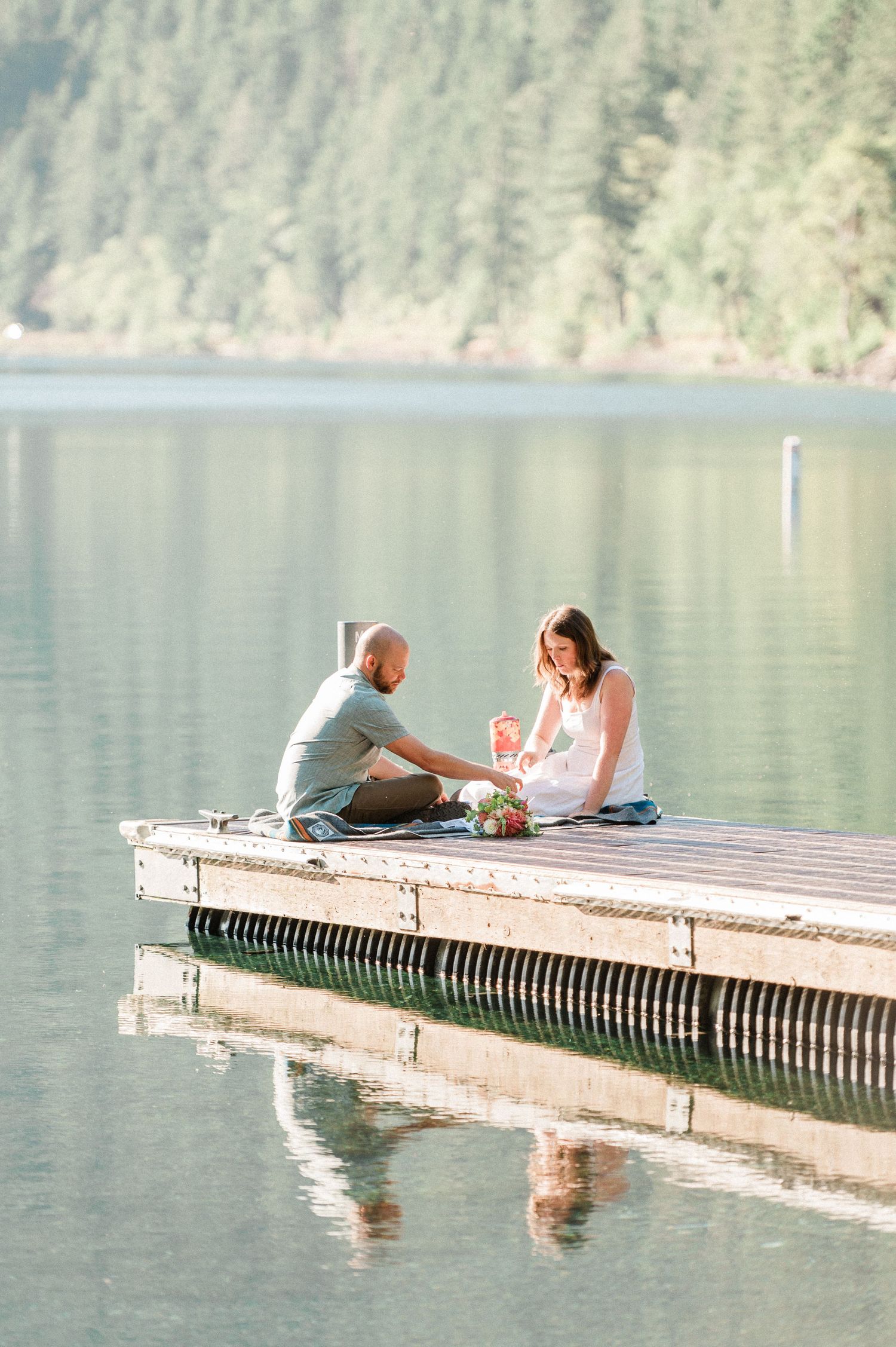 couple sits together on dock during elopement