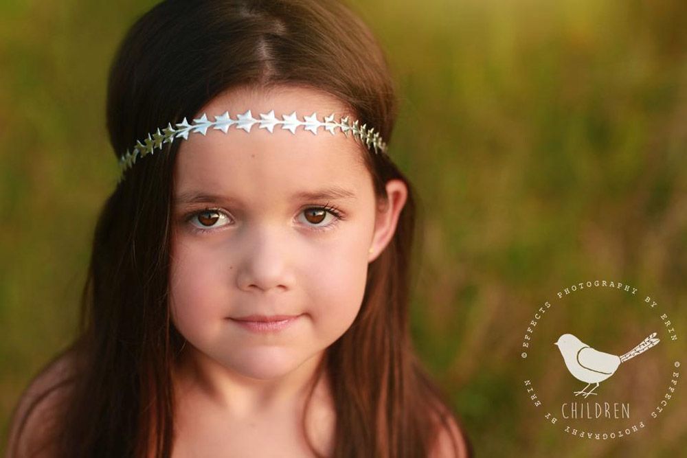 Portrait showcasing delicate crystal headband against natural outdoor backdrop.