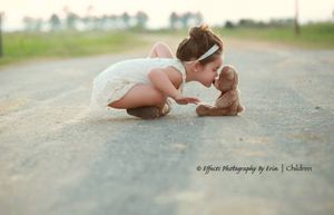 A tender moment captured on a rural road with white dress and soft lighting.
