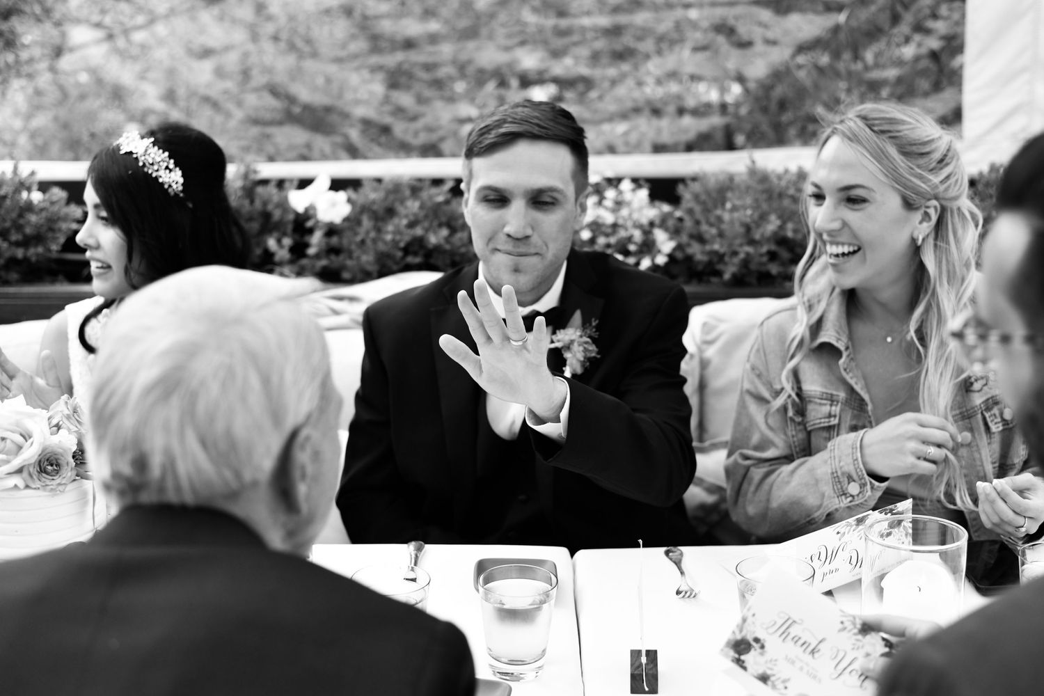 Series of black and white candid wedding reception photos showing emotional moments between guests.