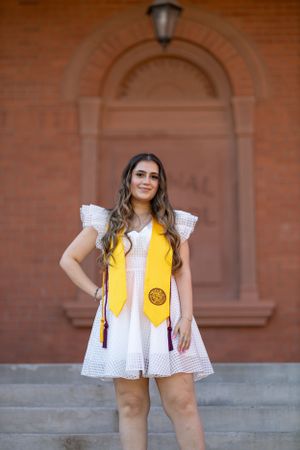 College Senior holding her cap and gown posing for her senior pictures.