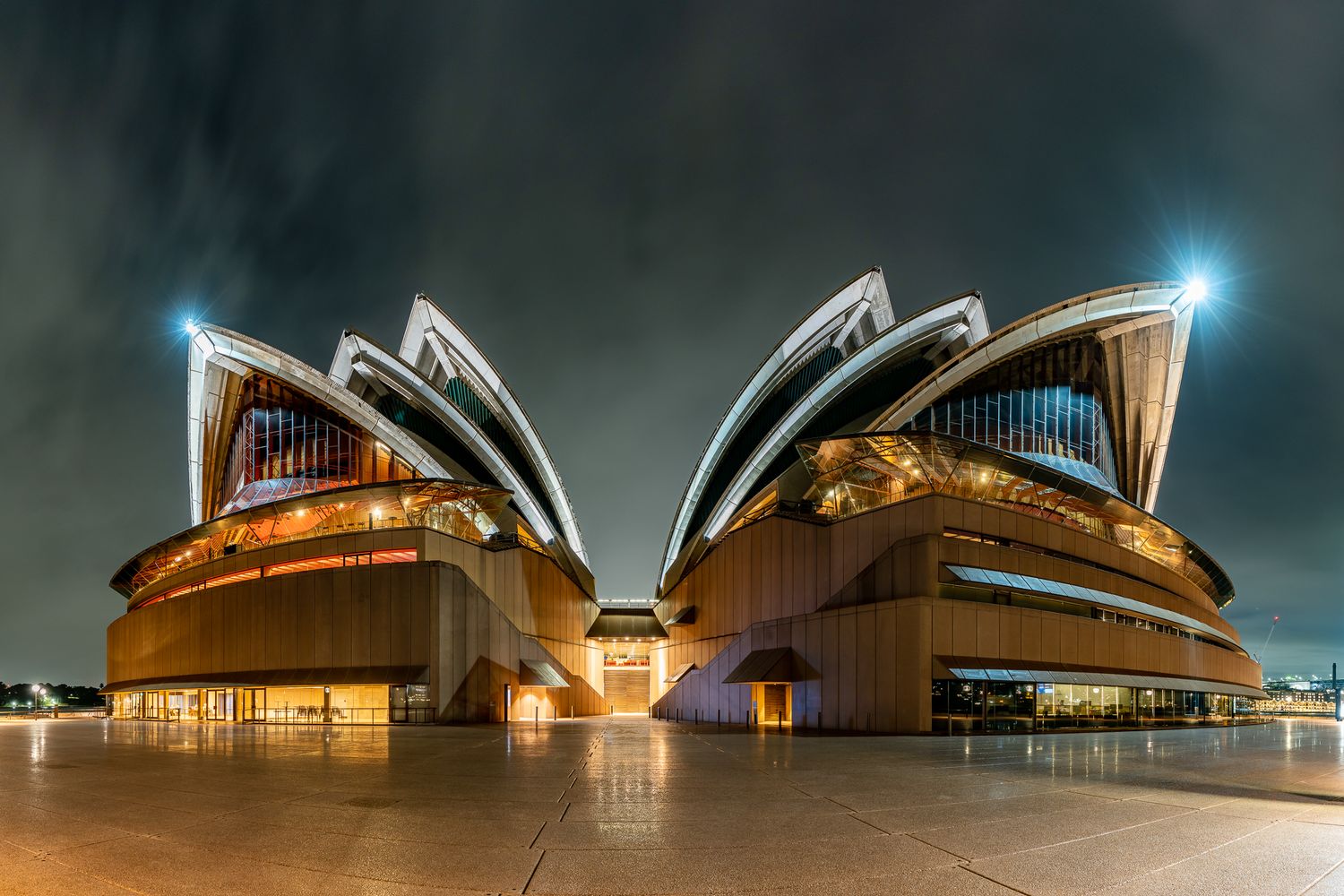 Sydney Opera House illuminated at night showcasing its iconic white shell-shaped roof architecture.