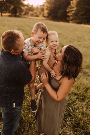 chasing toddlers in a field for family photography session