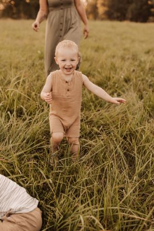 chasing toddlers in a field for family photography session