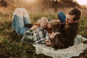 snuggle on a blanket in a field with family for family photography