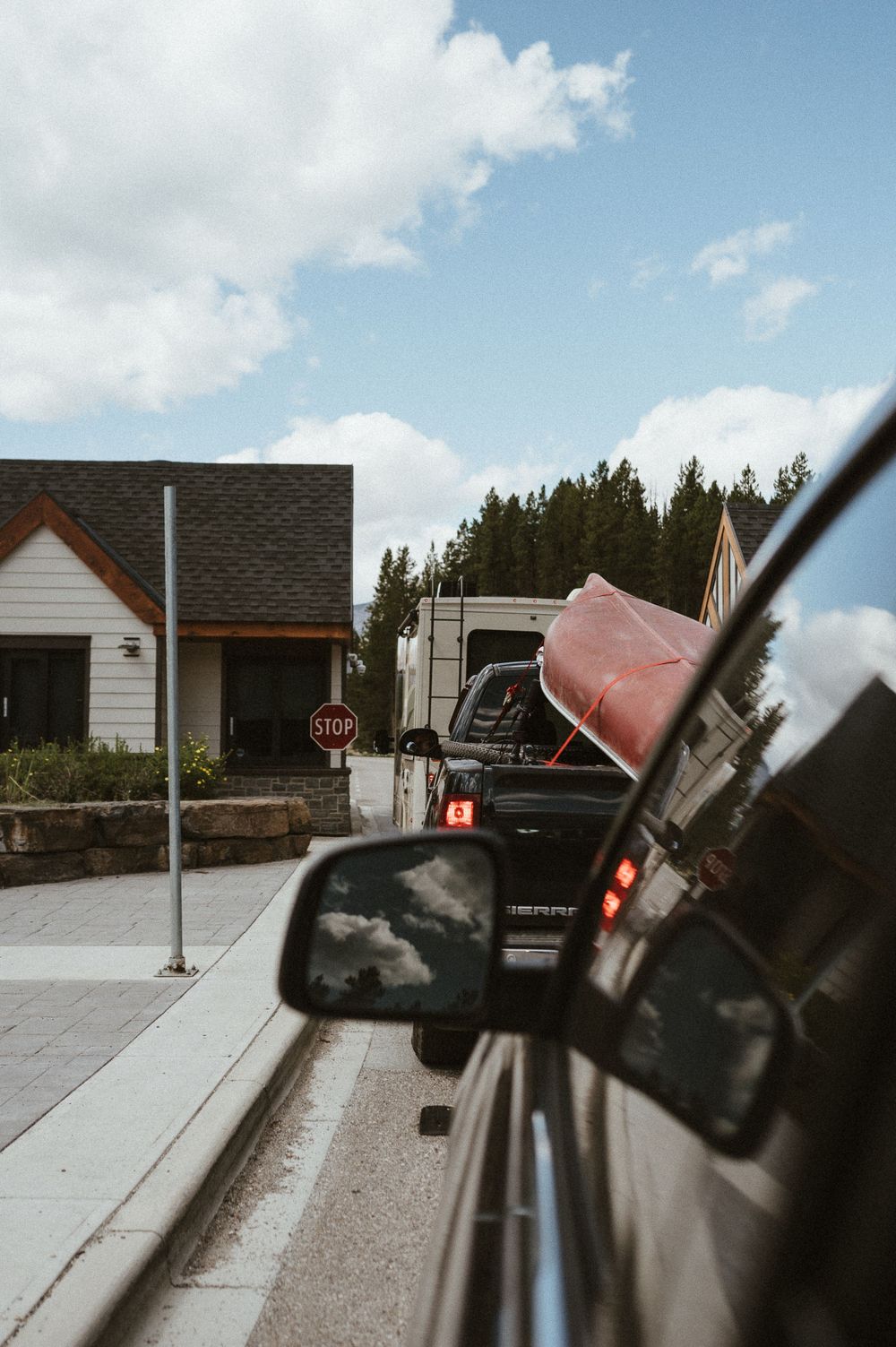 View of residential house and RV from car window on suburban street.