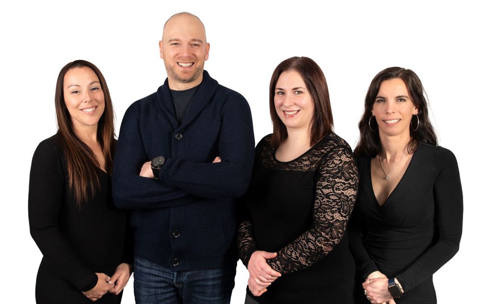 Corporate team photo of professionals in business attire against white background.