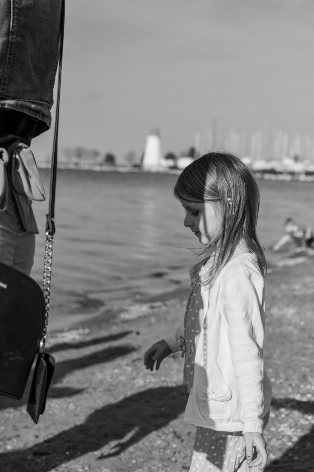 A black-and-white photo of a young girl at the beach