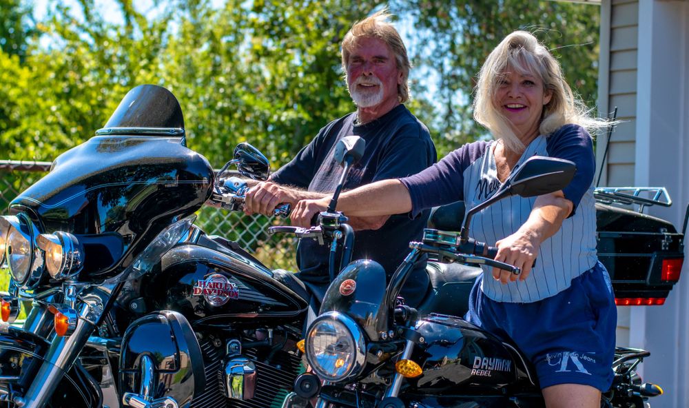 A couple posing on their motorcycles