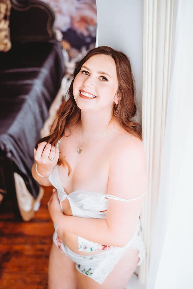 Pretty woman poses and smiles during her bridal boudoir session in downtown Cape Girardeau boudoir studio.