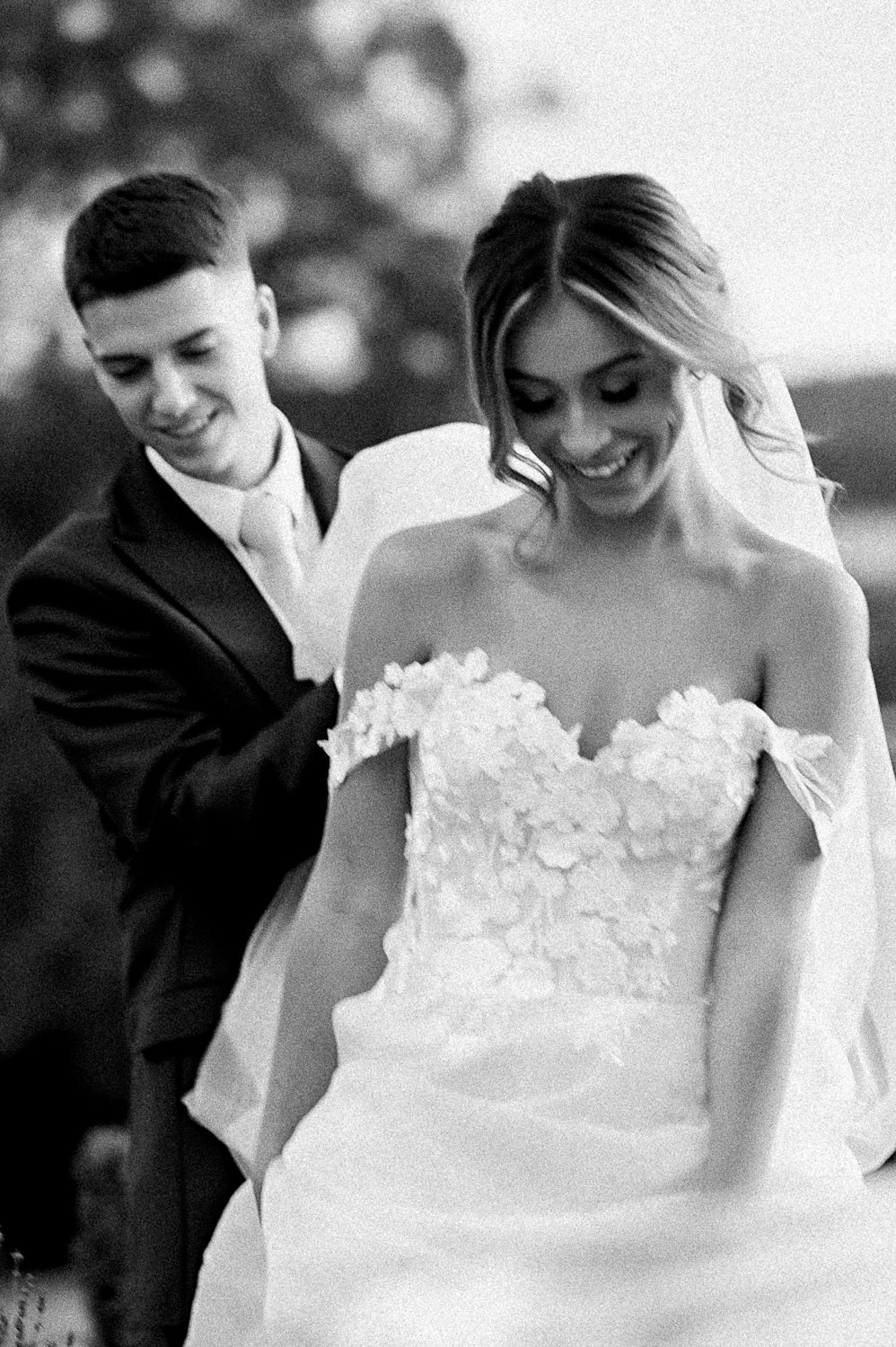 Black and white intimate moment between couple in formal wedding attire.