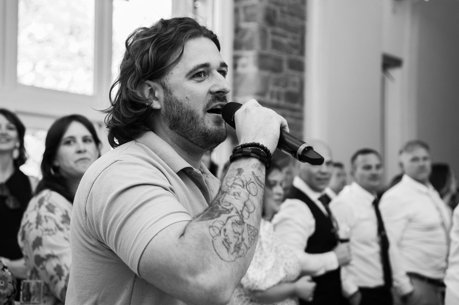 A wedding reception dinner party with guests celebrating at tables in a rustic stone venue.