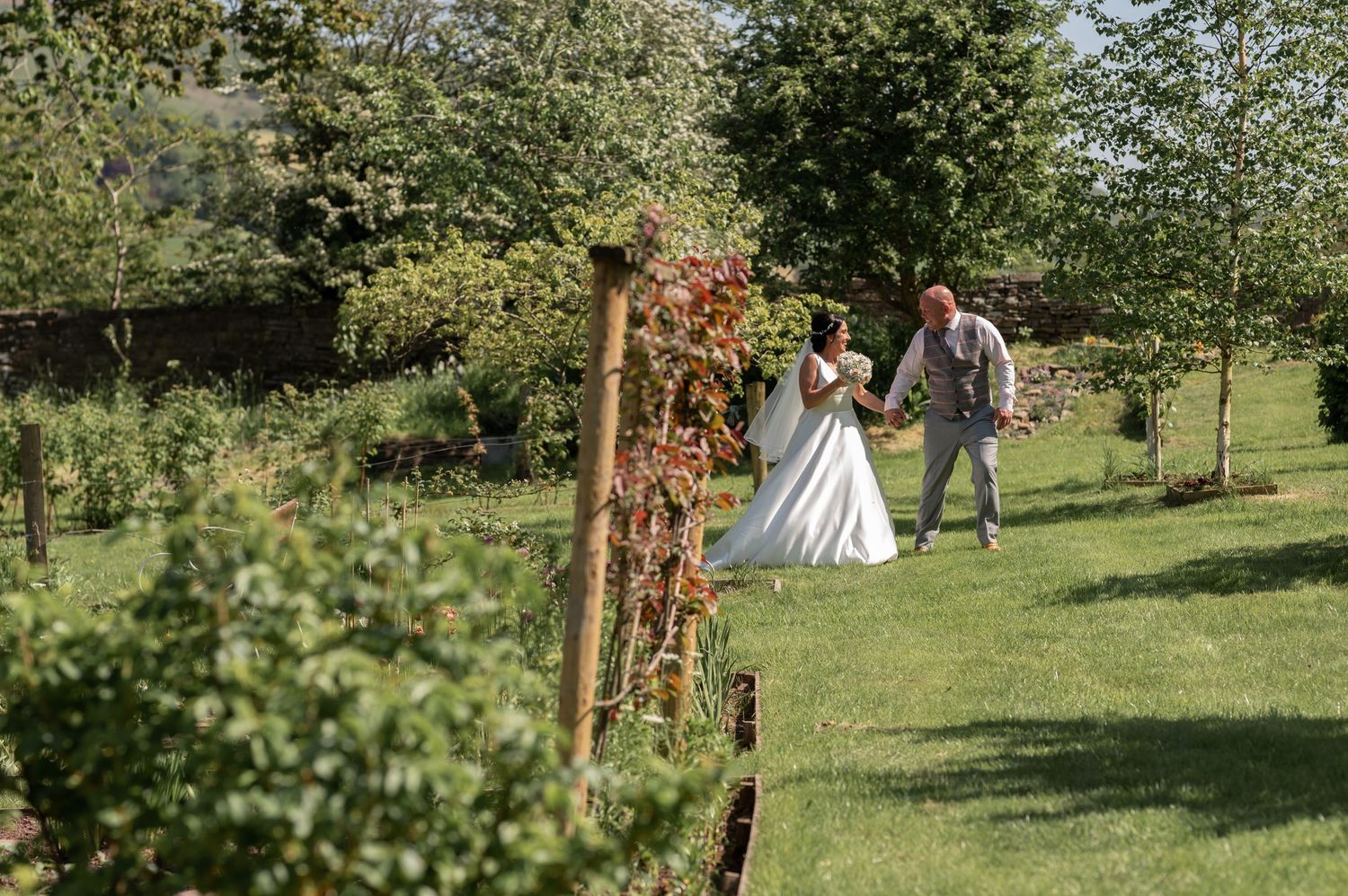 Outdoor wedding party photos taken in lush green garden setting.