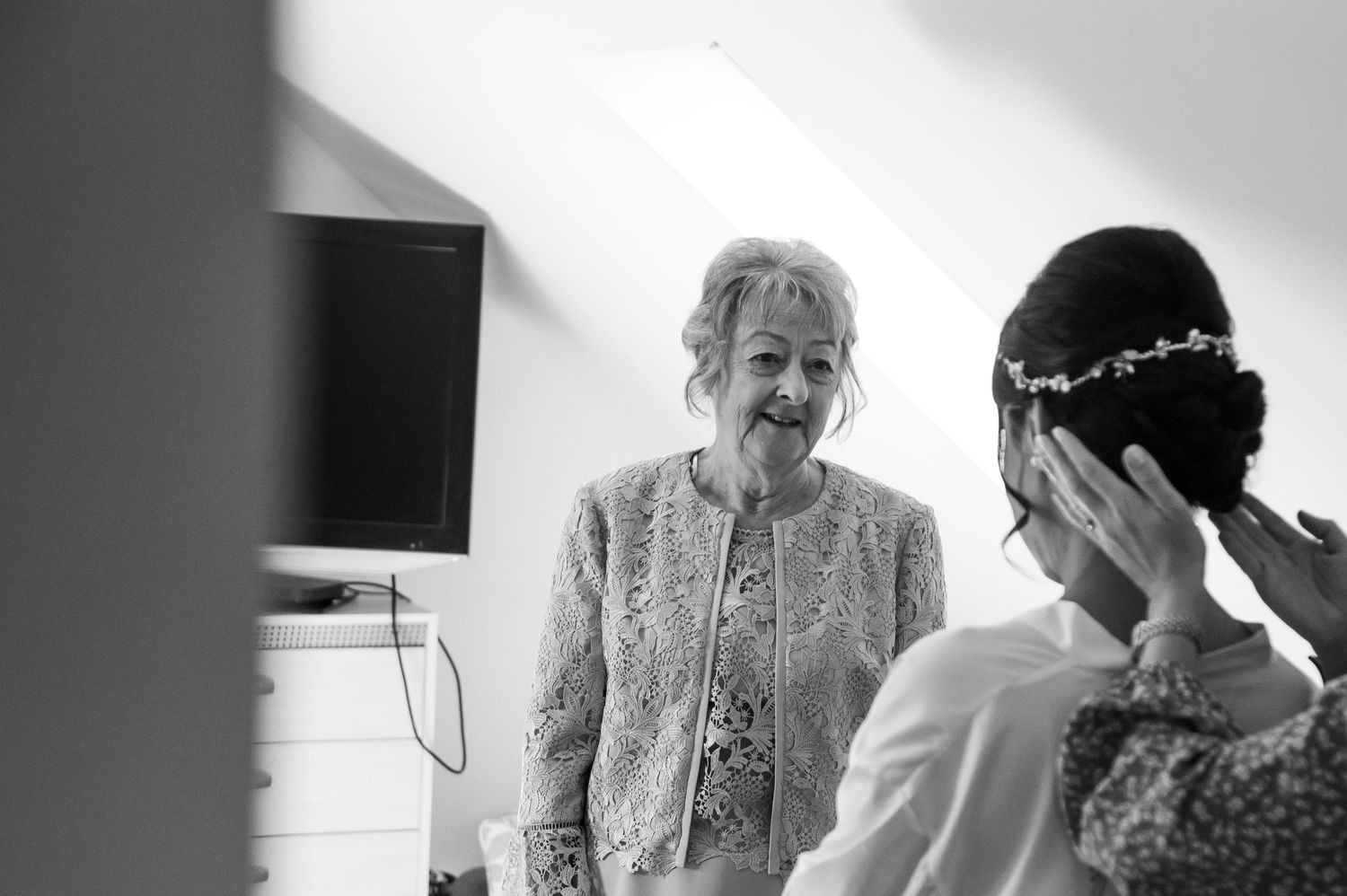 Wedding preparations show emotional embraces and tender moments in black and white.