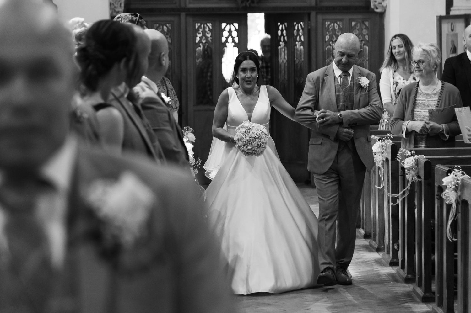 Traditional church wedding ceremony with guests seated in wooden pews.