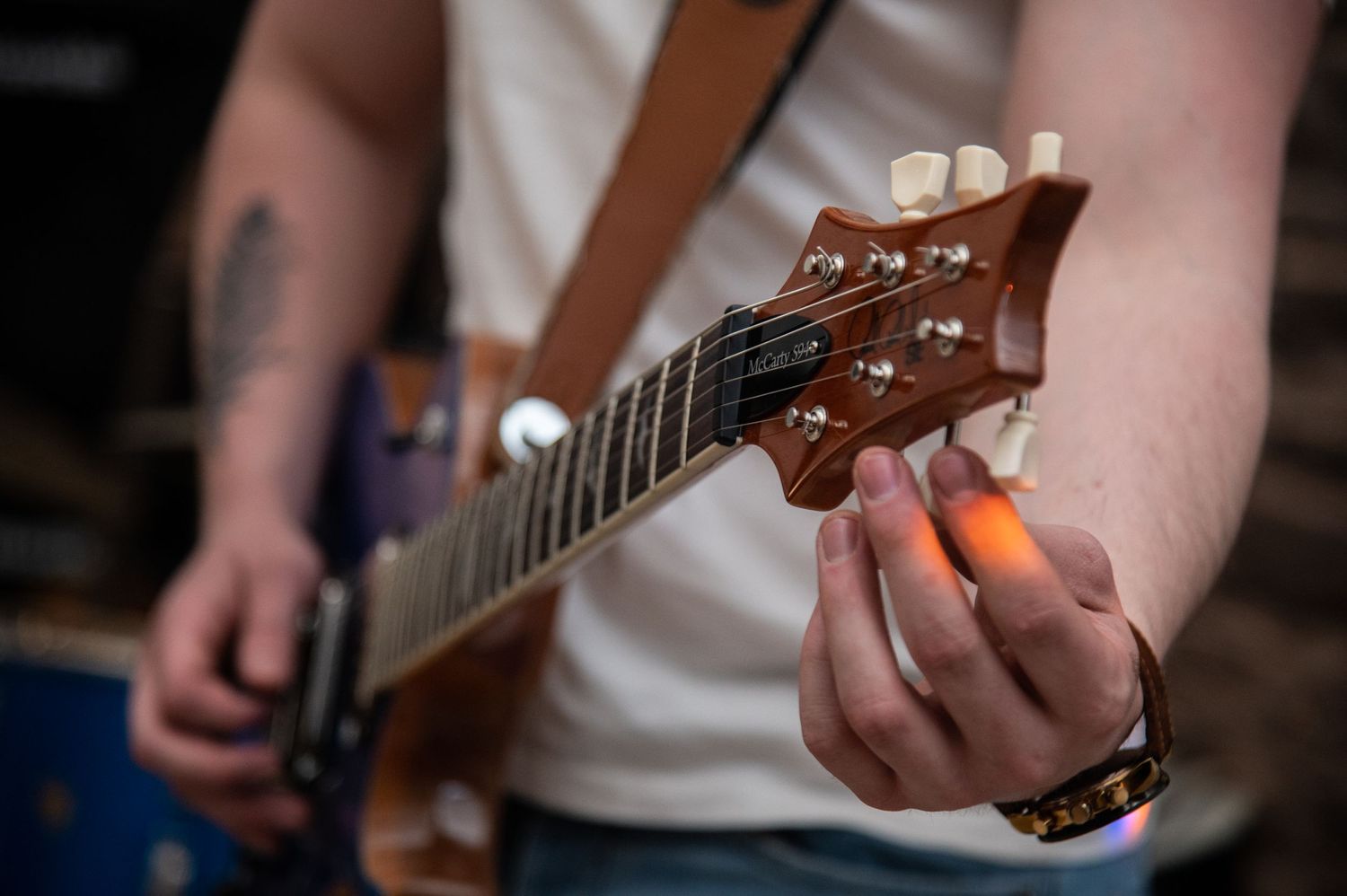 Close-up shots of hands playing acoustic guitar strings during a performance.
