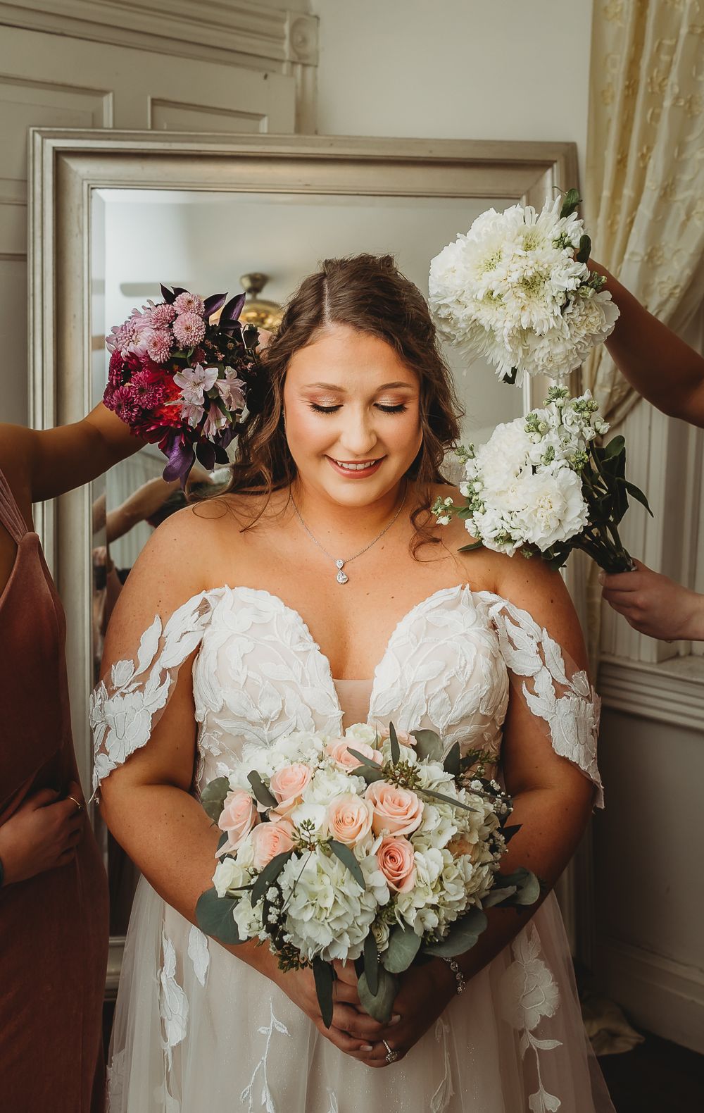 Bridal portrait featuring an off-shoulder lace gown and peach and white bouquet.