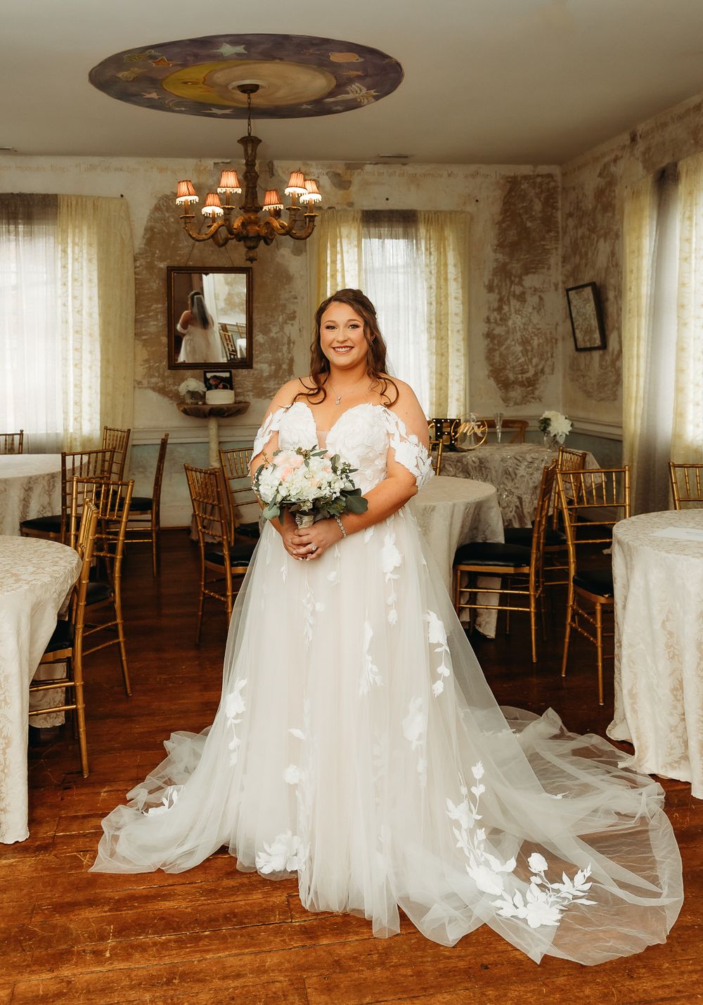 Elegant bridal portrait in vintage room with chandelier and white lace gown.