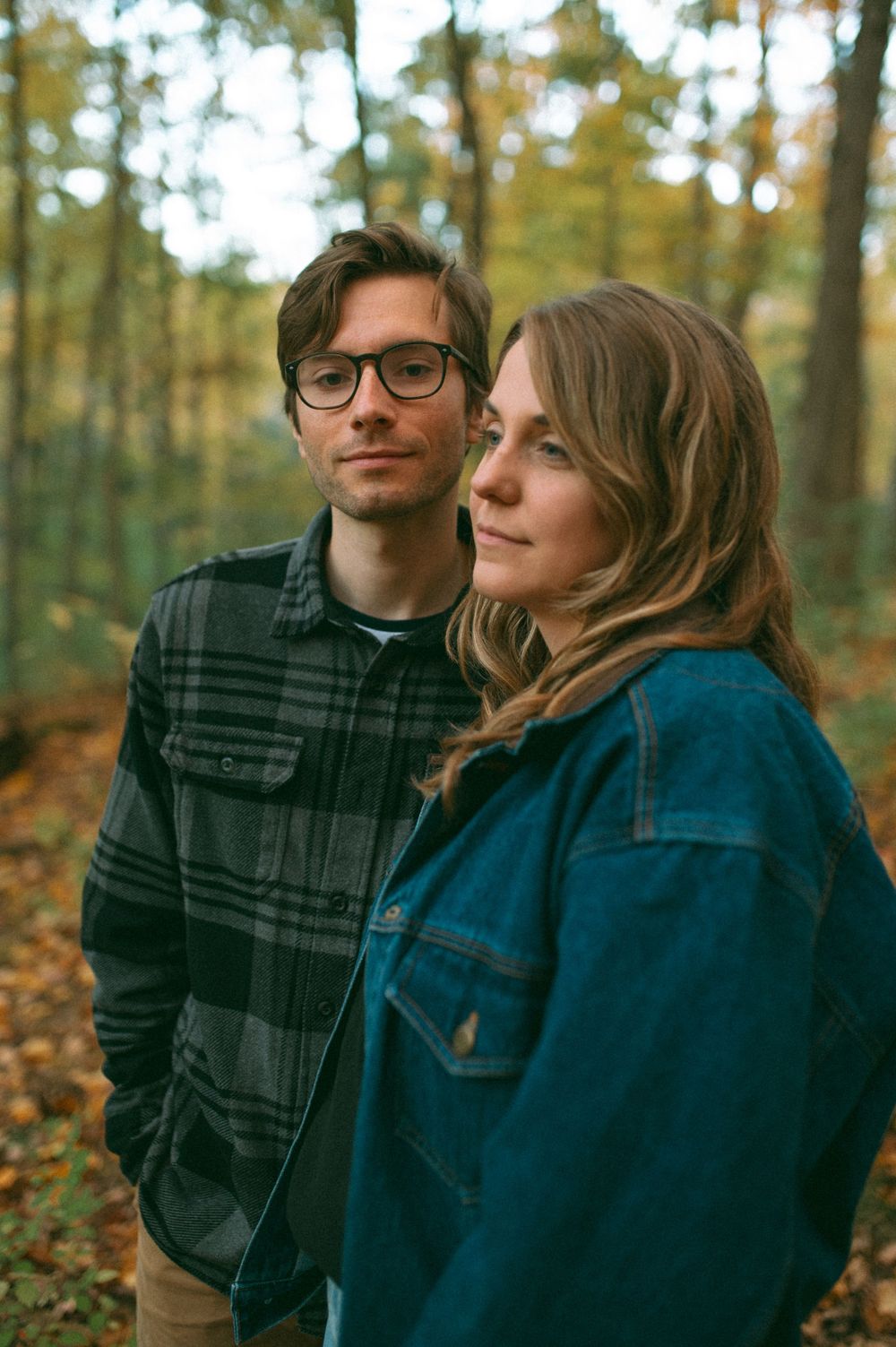Casual portrait in autumn forest with golden sunlight filtering through trees.