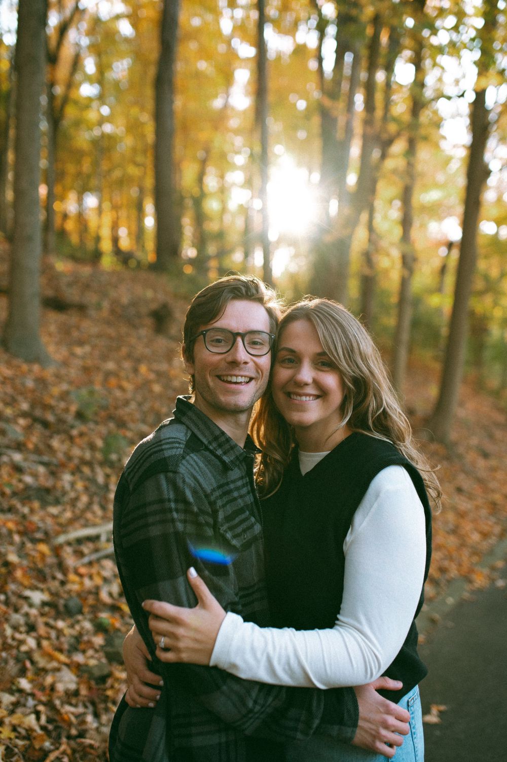 Autumn photoshoot in a golden forest with sun flare peeking through the trees.