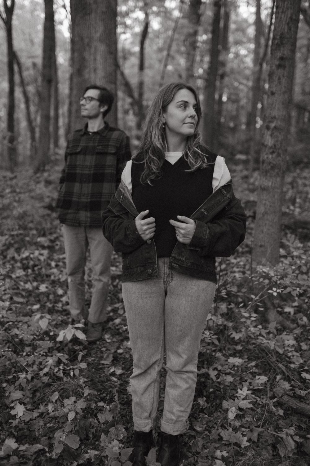 Black and white portrait in forest with plaid shirt and casual autumn wear.