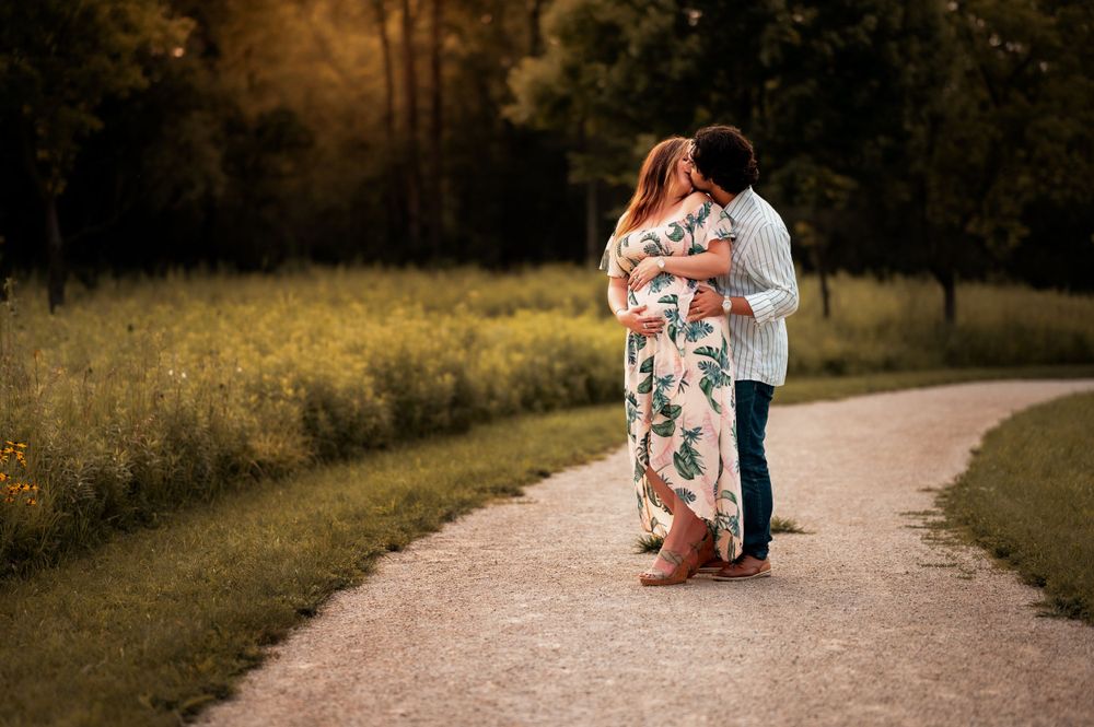 Romantic couple embracing on a path surrounded by golden autumn foliage at sunset.