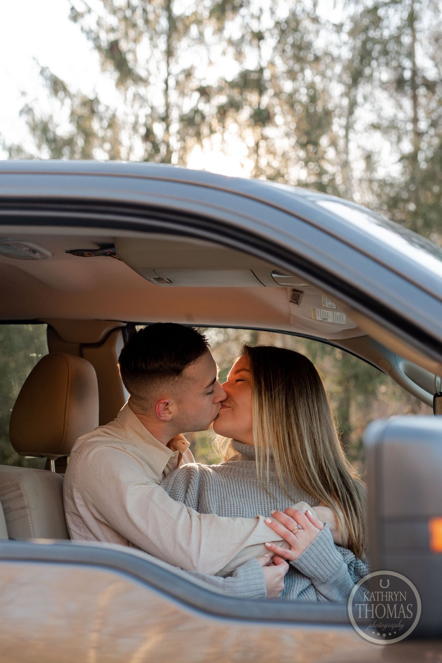 Romantic moment captured through car window as couple shares tender kiss.