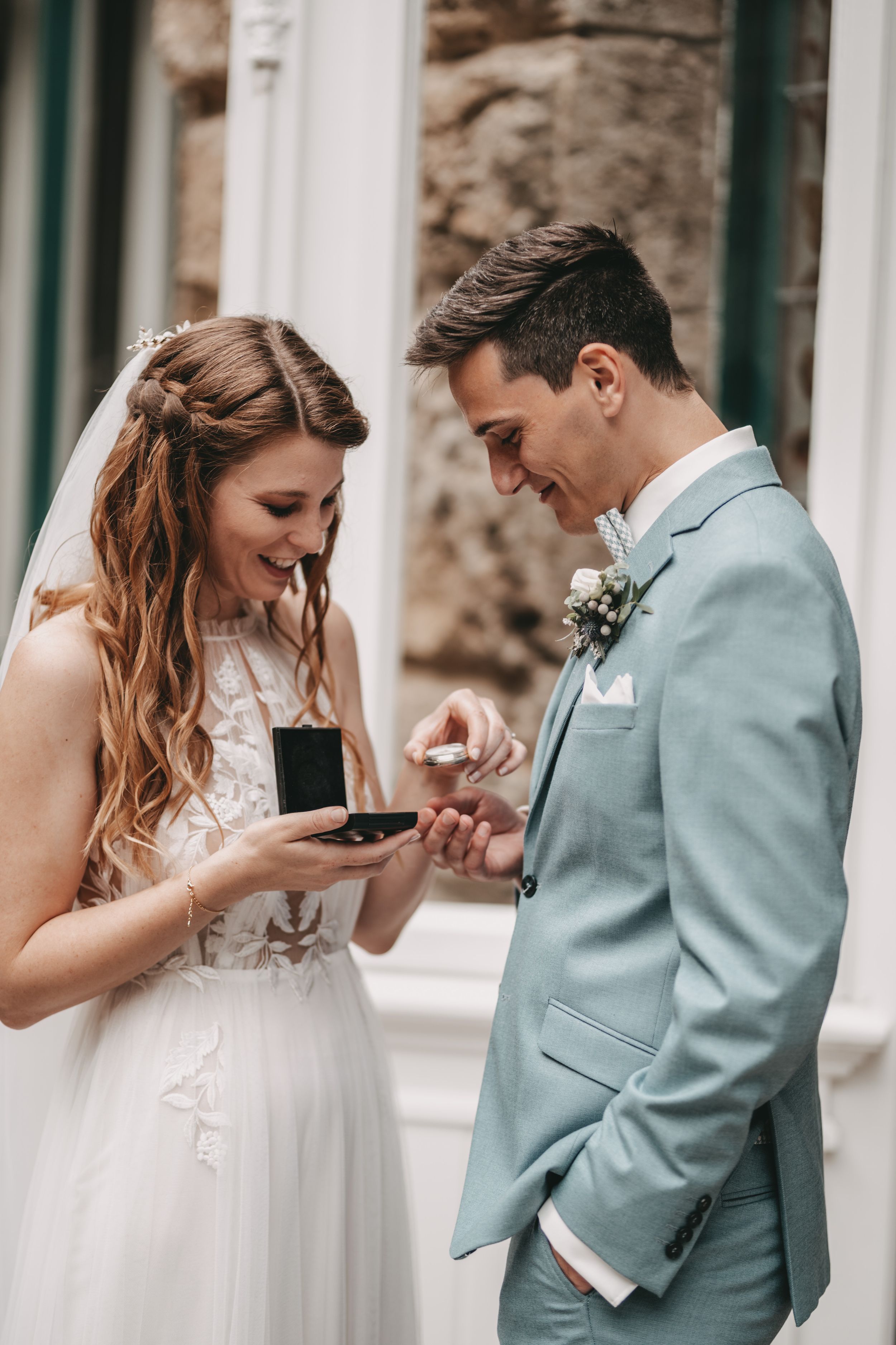 A couple in wedding attire sharing a tender moment outdoors.