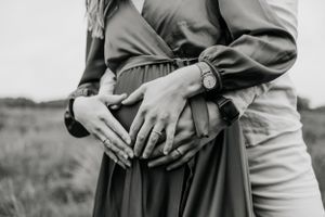 Man en vrouw houden haar zwangere buik vast