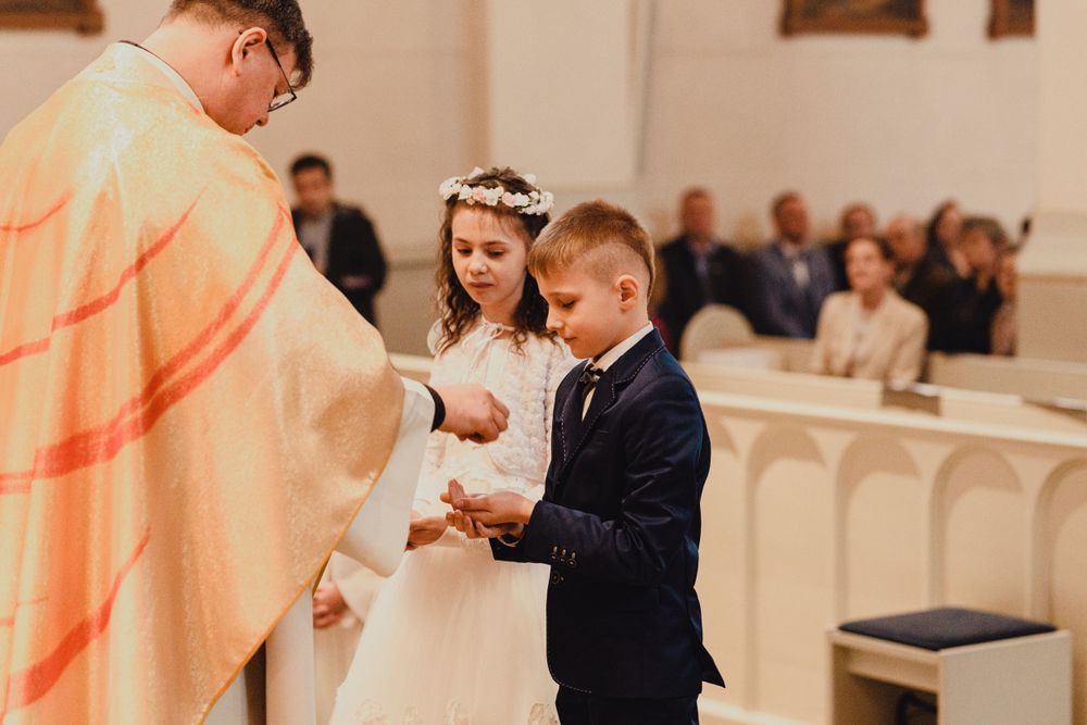 Formal ceremony in a church with decorative lighting and traditional interior.