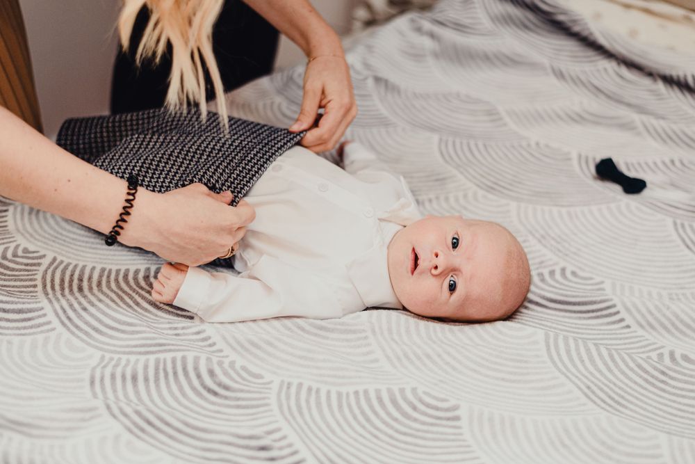 Baby lying on a patterned blanket during a photoshoot.