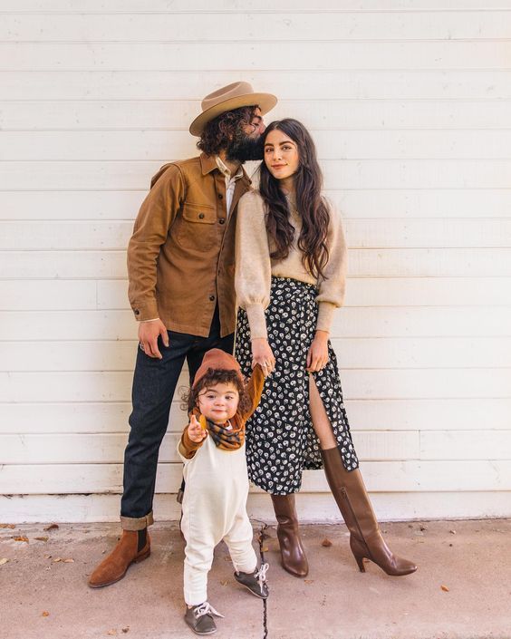 Lifestyle family photos against white wall wearing western-inspired outfits in brown and polka dots.