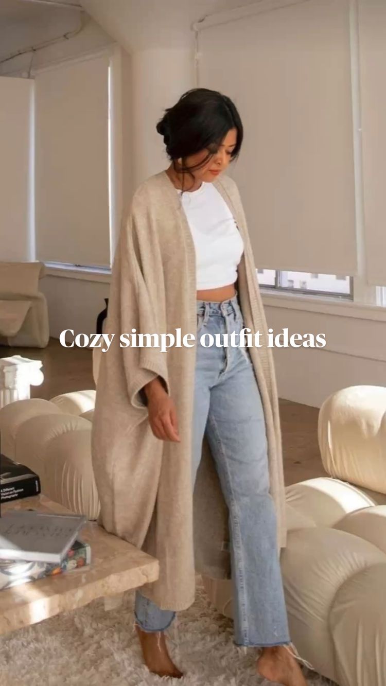 Cozy minimal outfit with long beige cardigan, white crop top and relaxed fit jeans.
