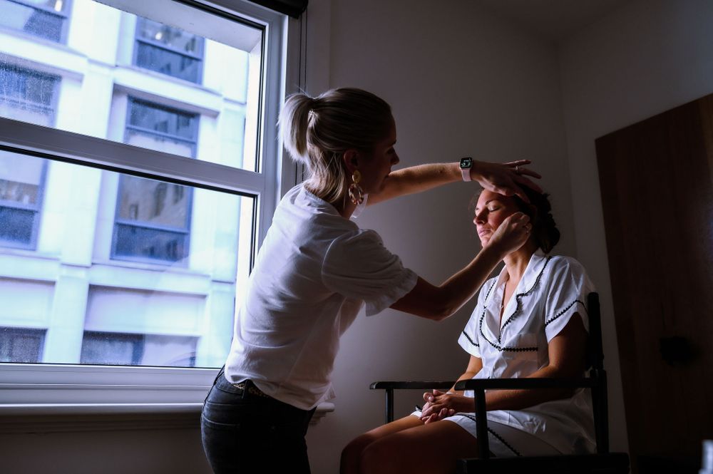 Person getting hair styled in bright room near window.
