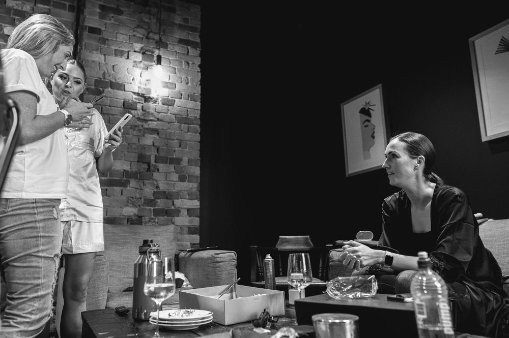 Two figures engaged in conversation at table with exposed brick wall and pendant lighting.