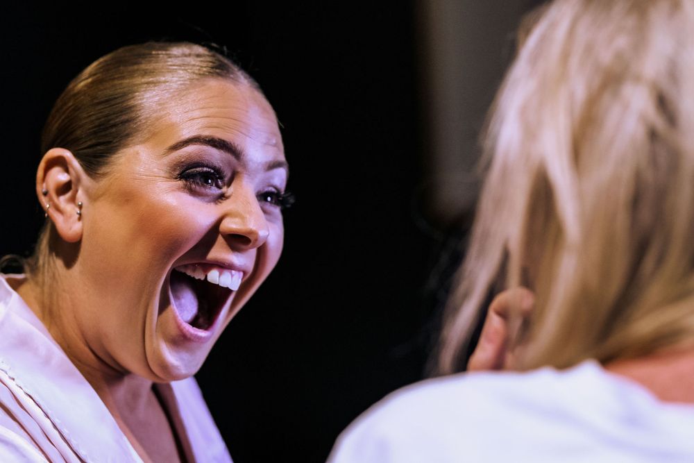 Close-up shot of excited laughter during animated conversation in dark setting.